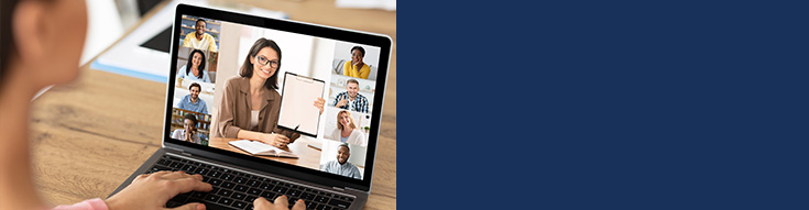 Person attending a video conference on a laptop, where a woman is presenting with a clipboard to a group of participants.