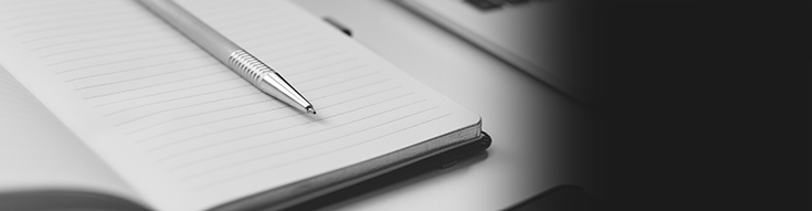 A white notepad with a pen in the middle.