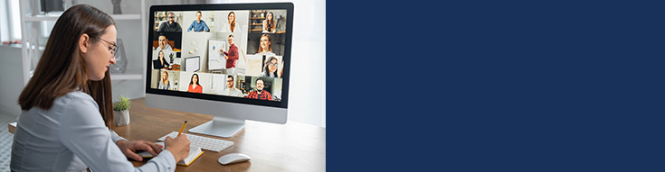 Woman taking notes while attending a virtual meeting on a computer with multiple people on screen.