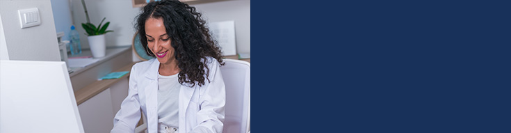 Smiling female doctor working at a desk in a medical office.